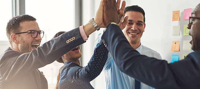 V1_Work_Together_Innovation_NuSkin_compressed a group of people in business attire high-five each other.