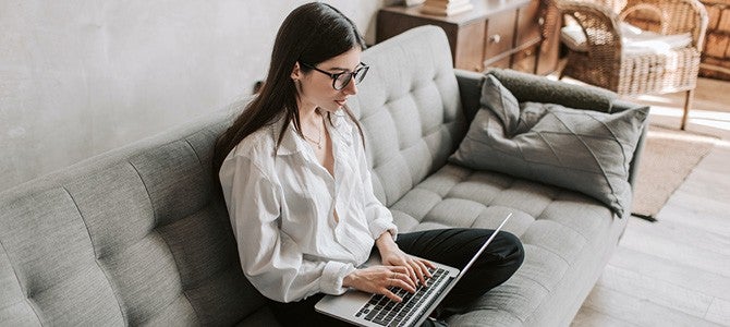 Gig Economy-04 girl sitting on a couch with a laptop